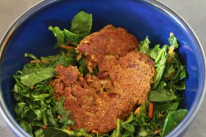 Black bean burger over bed of greens